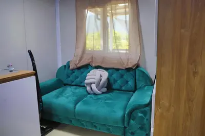 a green couch in a room with a window at Tiny House Ljiljan in Bihać