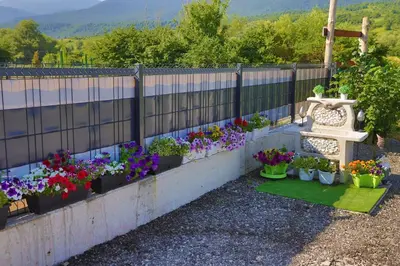 a bunch of flowers in pots on a fence at Tiny House Ljiljan in Bihać