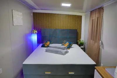 a bedroom with a large bed in a room at Tiny House Ljiljan in Bihać