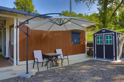 a patio with a table and chairs under an umbrella at Tiny House Ljiljan in Bihać