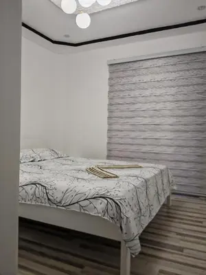a white bedroom with a bed with a window at Apartman Nermin 2 in Travnik