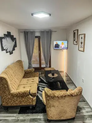 a living room with two couches and a flat screen tv at Stan na dan Apartman Durakovic in Cazin