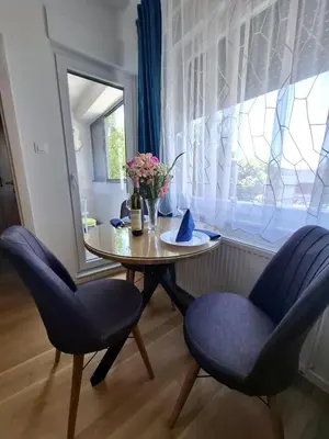 a dining room table with two chairs and a window at Apartman Sweet in Prijedor