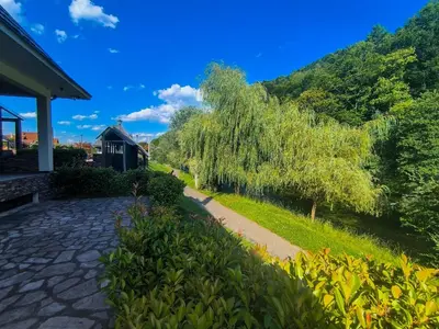 a walkway next to a house with a tree at Vikendica Sara in Šipovo