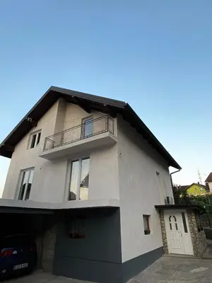 a white house with a balcony and a garage at Anes House in Sokolac