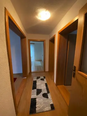 an empty hallway with a door and a checkered rug at Anes House in Sokolac