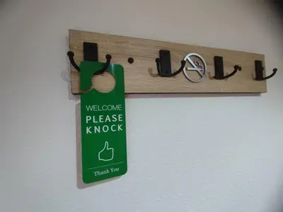 a sign that says welcome to please knock hanging on a wall at Green Stay in Velika Kladuša