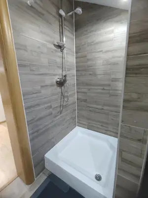 a shower with a white tub in a bathroom at Green Stay in Velika Kladuša