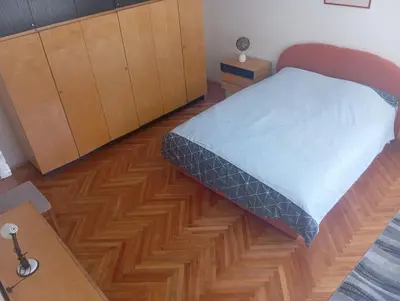 a bedroom with a bed and a wooden floor at MAM apartmani in Bosanski Brod