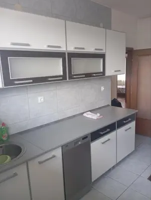 a kitchen with white cabinets and a sink at MAM apartmani in Bosanski Brod