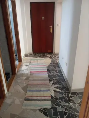a hallway with a door and a rug on the floor at MAM apartmani in Bosanski Brod