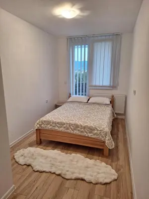 a bedroom with a bed and a window and a rug at Bugojno centar in Bugojno
