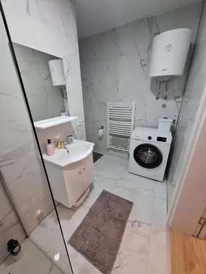 a bathroom with a sink and a washing machine at Bugojno centar in Bugojno