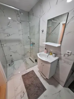 a white bathroom with a sink and a shower at Bugojno centar in Bugojno