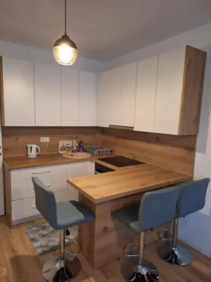 a kitchen with a wooden counter and two chairs at Bugojno centar in Bugojno