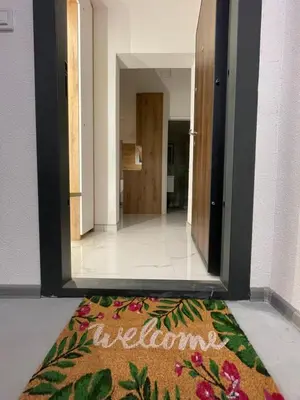 a welcome mat on the floor in a hallway at ALTI Modern & Comfort Apartment - Free Garage Parking in Tuzla