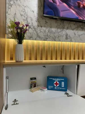a vase of flowers on a shelf with a tv at ALTI Modern & Comfort Apartment - Free Garage Parking in Tuzla