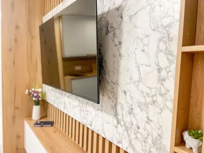 a bathroom with a mirror and a white marble wall at ALTI Modern & Comfort Apartment - Free Garage Parking in Tuzla