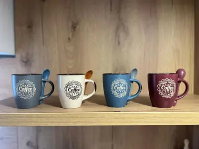 four coffee mugs are sitting on a shelf at ALTI Modern & Comfort Apartment - Free Garage Parking in Tuzla