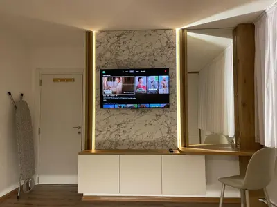 a living room with a mirror and a tv on a wall at ALTI Modern & Comfort Apartment - Free Garage Parking in Tuzla