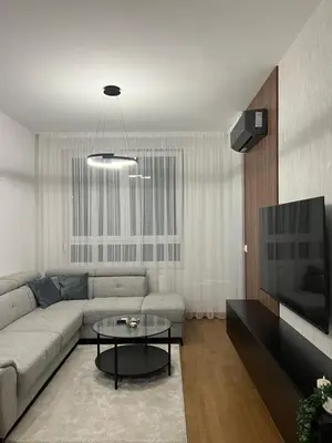 a living room with a couch and a table at Lux Apartman Kotor Varoš in Donja Varoš