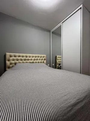 a bedroom with a large bed and a mirror at Lux Apartman Kotor Varoš in Donja Varoš