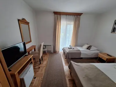 a hotel room with two beds and a flat screen tv at Villa Una in Bihać