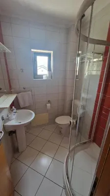 a bathroom with a shower and a sink and a toilet at Villa Una in Bihać