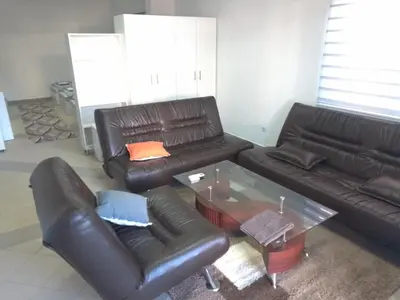 a living room with two leather couches and a glass table at Vila Gunša in Šipovo