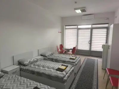 a bedroom with two beds and a table and chairs at Vila Gunša in Šipovo
