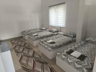a room with three beds and a window at Vila Gunša in Šipovo