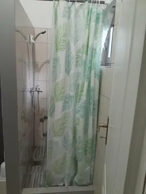a shower curtain with a green leaf pattern on it at Vila Gunša in Šipovo
