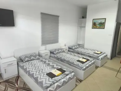 a room with three beds and a flat screen tv at Vila Gunša in Šipovo