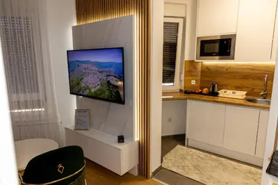 a kitchen with a flat screen tv on a wall at Urban Studio I