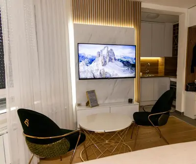 a room with a table and chairs and a tv on the wall at Urban Studio I