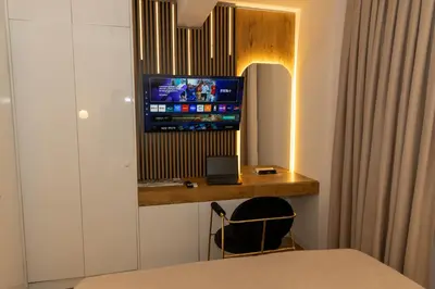 a room with a desk with a television on a wall at Urban Studio II