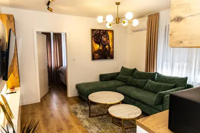 a living room with a green couch and two tables at Urban Studio II