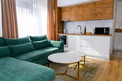 a living room with a green couch and a table at Urban Studio II