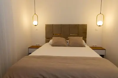 a bedroom with a large bed with two lamps at Urban Studio II