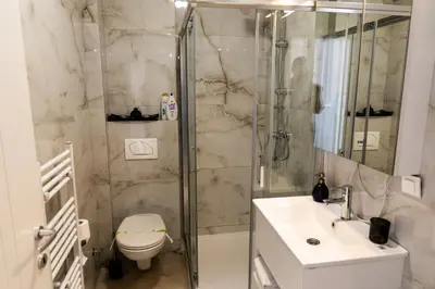 a bathroom with a shower and a toilet and a sink at Urban Studio II