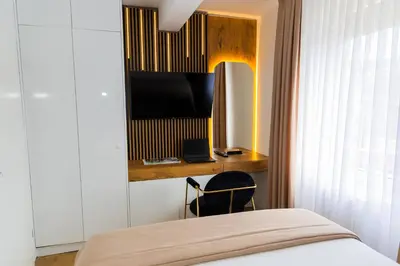 a bedroom with a bed and a television on a wall at Urban Studio II