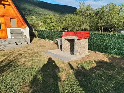 a shadow of a person standing next to a bench at Adna 's Home in Orašac