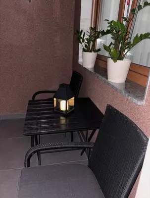 a table with a candle on it next to two chairs at Apartman Andjela Doboj in Doboj