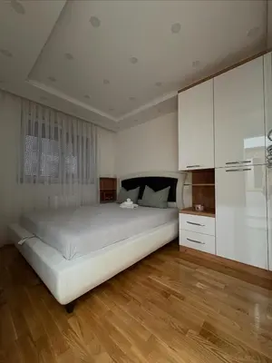 a bedroom with a large bed and white cabinets at Apartman Andjela Doboj in Doboj
