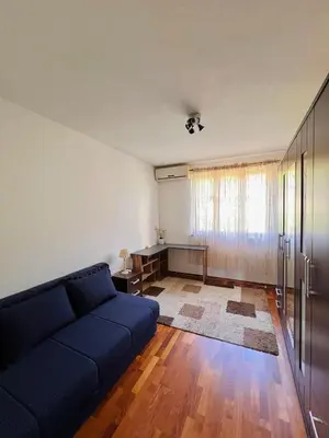 a living room with a blue couch and a table at Apartman Hela in Ivišovo Greblje