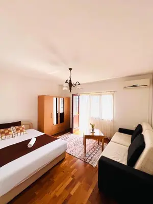 a bedroom with a large bed and a couch at Apartman Hela in Ivišovo Greblje
