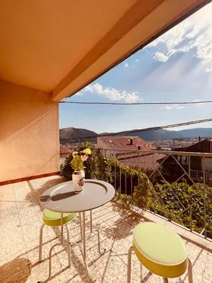 a balcony with a table and chairs and a view at Apartman Hela in Ivišovo Greblje
