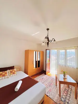 a bedroom with a large bed and a table at Apartman Hela in Ivišovo Greblje