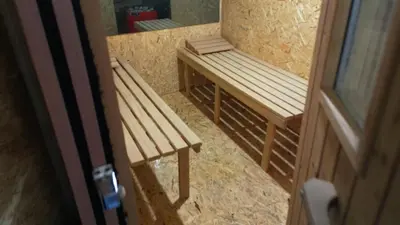 a wooden bench in a room with a door at Vikendica Brusnica