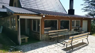 a pavilion with a glass table and a bench at Vikendica Brusnica
